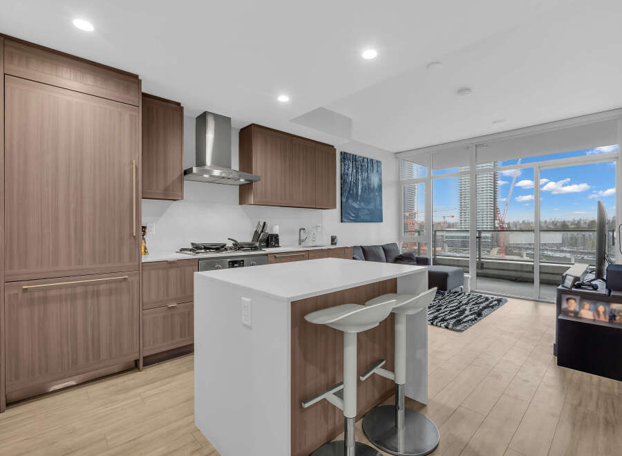 Experience modern living in this stunning condo featuring a sleek kitchen with integrated appliances and a spacious island perfect for entertaining.