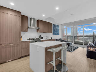 Experience modern living in this stunning condo featuring a sleek kitchen with integrated appliances and a spacious island perfect for entertaining.