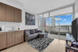 Experience modern urban living in this stylish condo featuring a sleek kitchen with ample cabinet space and a spacious living area.