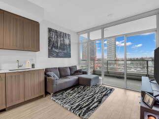 Experience modern urban living in this stylish condo featuring a sleek kitchen with ample cabinet space and a spacious living area.