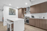 Experience modern living in this stunning kitchen, featuring sleek, dark wood cabinetry and a pristine white island with bar seating.