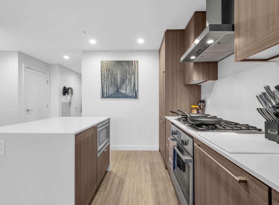 Experience modern living in this sleek kitchen, featuring a spacious island with a built-in microwave and ample counter space.