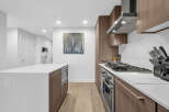 Experience modern living in this sleek kitchen, featuring a spacious island with a built-in microwave and ample counter space.