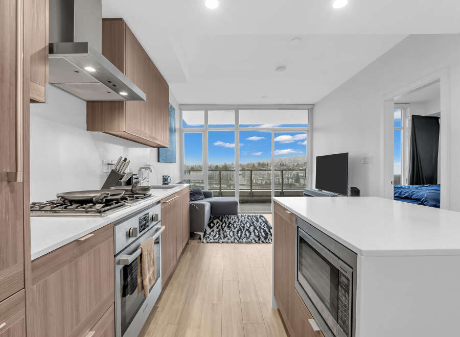 Experience modern living in this stunning condo featuring a sleek kitchen with stainless steel appliances and ample cabinet space.