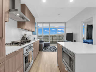 Experience modern living in this stunning condo featuring a sleek kitchen with stainless steel appliances and ample cabinet space.