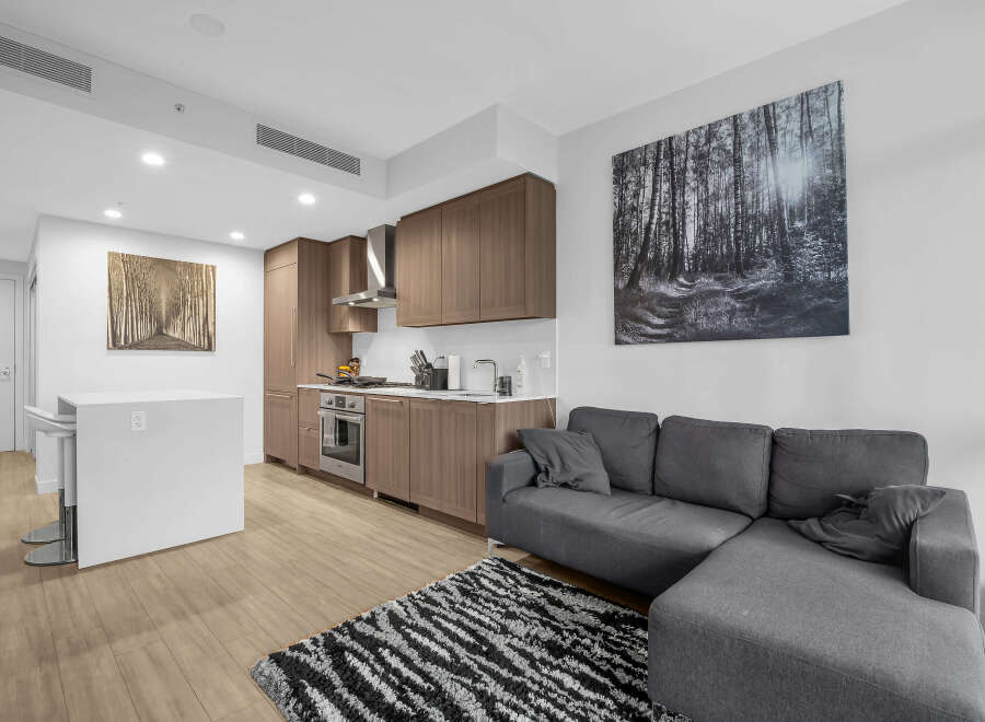 Experience modern living in this stylish condo featuring a sleek, open-concept kitchen with rich wood cabinetry and stainless steel appliances.