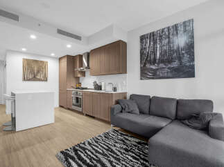 Experience modern living in this stylish condo featuring a sleek, open-concept kitchen with rich wood cabinetry and stainless steel appliances.