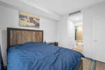 Experience comfort and style in this inviting bedroom, featuring a striking wooden headboard and a plush blue duvet.