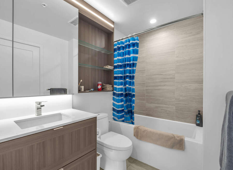 Experience modern comfort in this beautifully appointed bathroom, featuring a sleek vanity with ample storage and a stylish chrome faucet.
