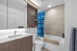Experience modern comfort in this beautifully appointed bathroom, featuring a sleek vanity with ample storage and a stylish chrome faucet.