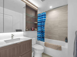 Experience modern comfort in this beautifully appointed bathroom, featuring a sleek vanity with ample storage and a stylish chrome faucet.