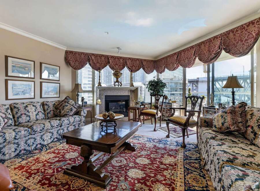 Experience luxurious living in this elegant living room, featuring a grand fireplace and plush, patterned sofas perfect for relaxation.