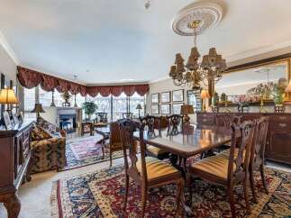 Experience elegant dining in this formal dining room, featuring a large, polished wood table surrounded by intricately carved chairs.