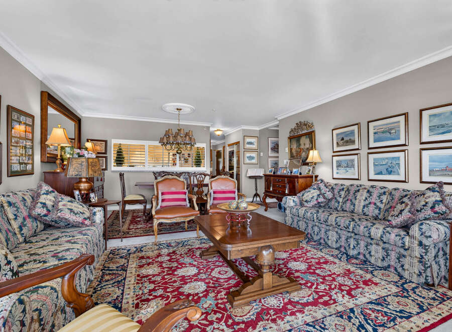 Step into this elegant living room, featuring a plush floral sofa and a matching armchair, perfect for relaxing.