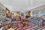 Step into this elegant living room, featuring a plush floral sofa and a matching armchair, perfect for relaxing.