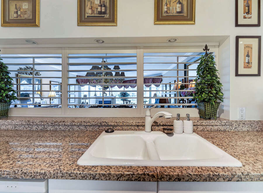 This kitchen features a spacious double basin sink set into a granite countertop, perfect for meal prep and cleanup.