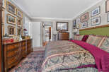Step into this luxurious bedroom featuring a plush king-sized bed adorned with elegant bedding and a striking green tufted headboard.
