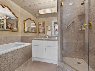 Indulge in luxury with this stunning bathroom featuring a deep soaking tub and a spacious walk-in shower.