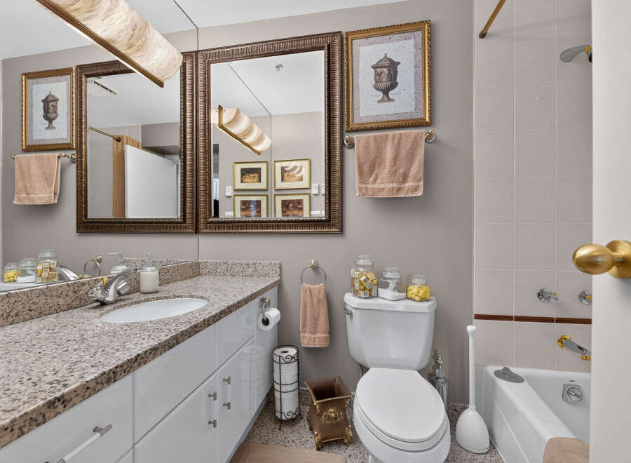 This elegant bathroom features a spacious vanity with a granite countertop and ample storage.