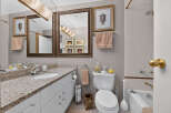 This elegant bathroom features a spacious vanity with a granite countertop and ample storage.