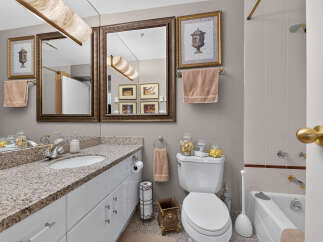 This elegant bathroom features a spacious vanity with a granite countertop and ample storage.