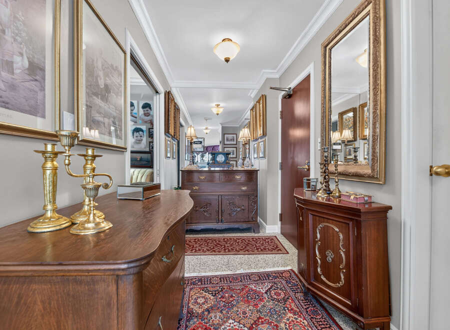 Step into this elegant hallway, featuring a grand antique dresser and a matching side cabinet, perfect for storage and display.