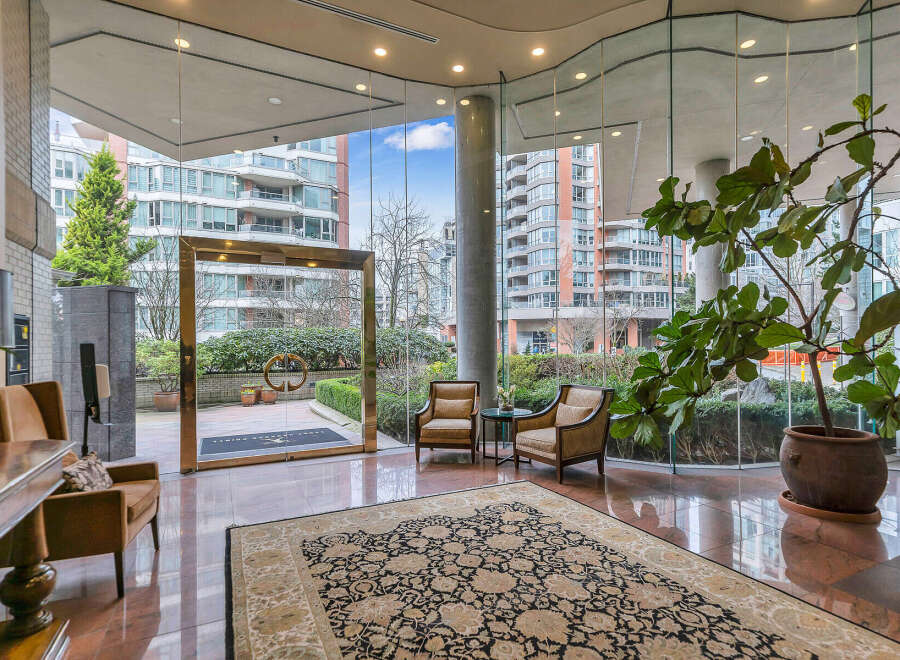 Step into a grand entrance with gleaming marble floors and a large, ornate rug, creating an elegant first impression.