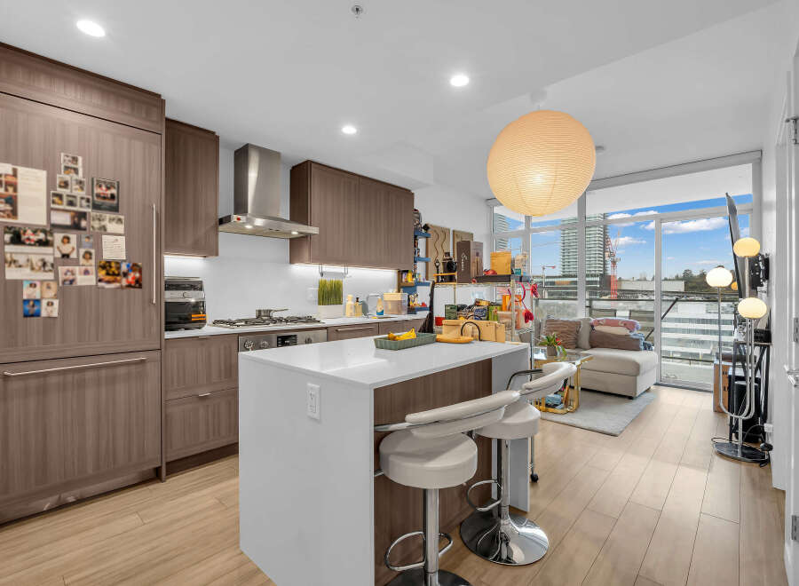 Experience modern urban living in this stunning condo featuring a sleek, contemporary kitchen with ample cabinetry and a spacious island perfect for entertaining.