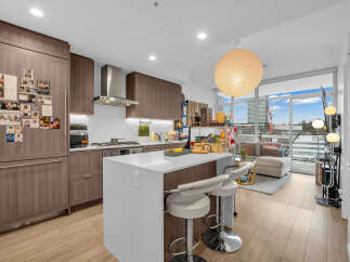 Experience modern urban living in this stunning condo featuring a sleek, contemporary kitchen with ample cabinetry and a spacious island perfect for entertaining.