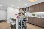 Experience modern living in this sleek kitchen featuring elegant wood cabinetry and a spacious island with bar seating.