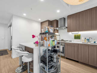 Experience modern living in this sleek kitchen featuring elegant wood cabinetry and a spacious island with bar seating.