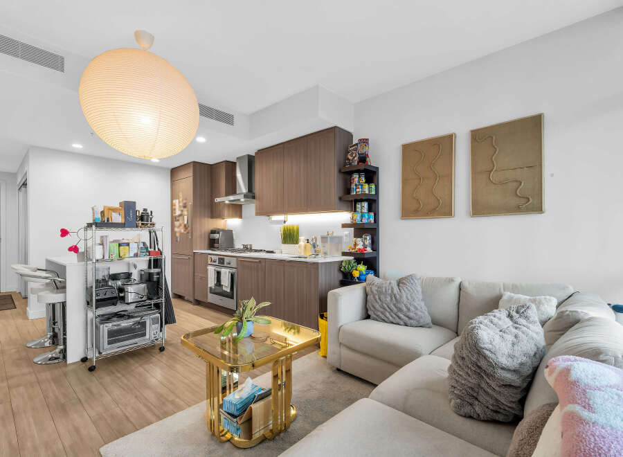 Experience modern urban living in this stylish condo featuring a sleek, open-concept kitchen with dark wood cabinetry and stainless steel appliances.