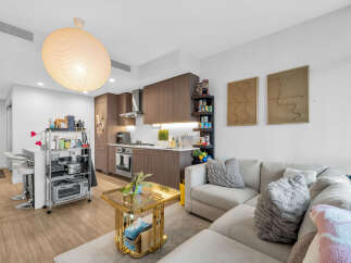 Experience modern urban living in this stylish condo featuring a sleek, open-concept kitchen with dark wood cabinetry and stainless steel appliances.