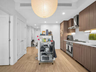 Experience modern living in this stylish apartment featuring a sleek, contemporary kitchen with rich wood cabinetry and stainless steel appliances.
