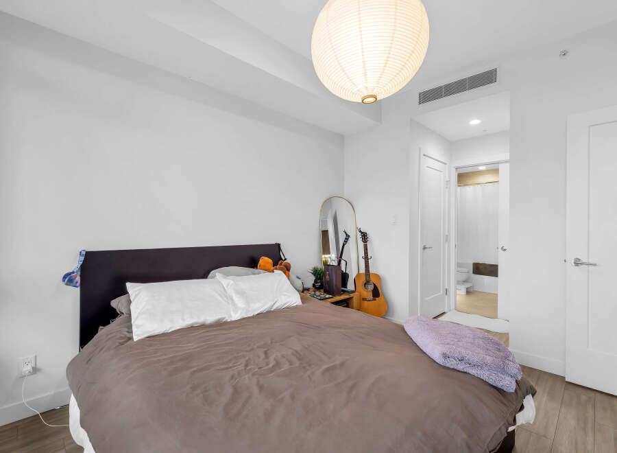 Experience comfort and style in this inviting bedroom, featuring a plush bed adorned with soft linens and decorative pillows.