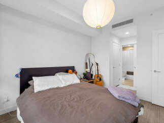 Experience comfort and style in this inviting bedroom, featuring a plush bed adorned with soft linens and decorative pillows.