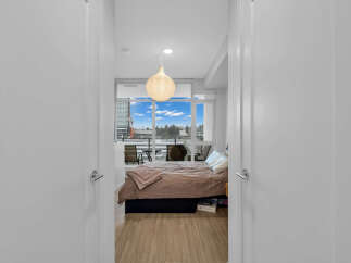 Step into this inviting bedroom featuring a comfortable bed with plush bedding and a stylish accent throw.