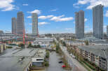 Experience modern urban living in this vibrant cityscape featuring sleek high-rise towers and contemporary apartment buildings.