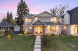 This stunning two-story home features a welcoming entrance with a white door and elegant landscaping.