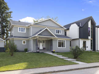 Discover modern living in this stunning new construction home, featuring a sleek grey exterior with contrasting white trim and a prominent gable roofline.