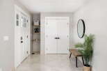 Step into this welcoming entryway featuring a bright white door with glass panes, complemented by sleek shelving for storage and decor.