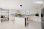 This stunning kitchen boasts elegant cream cabinetry complemented by a sleek gray subway tile backsplash.