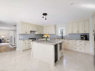 This stunning kitchen boasts elegant cream cabinetry complemented by a sleek gray subway tile backsplash.