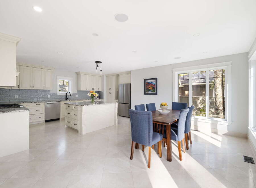 This spacious kitchen and dining area features elegant cream cabinetry, granite countertops, and a large island perfect for meal preparation and casual dining.