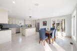 This spacious kitchen and dining area features elegant cream cabinetry, granite countertops, and a large island perfect for meal preparation and casual dining.