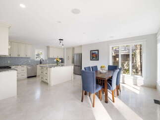 This spacious kitchen and dining area features elegant cream cabinetry, granite countertops, and a large island perfect for meal preparation and casual dining.