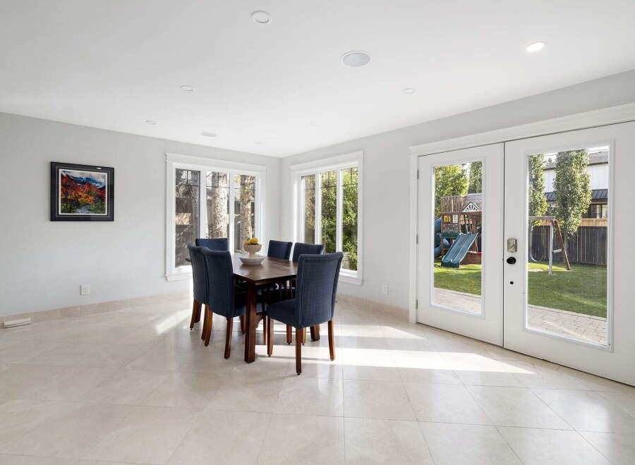 Enjoy bright and airy dining in this elegant space, featuring a large wooden table with comfortable upholstered chairs.