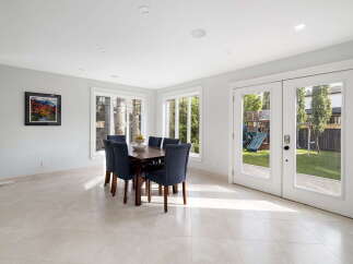 Enjoy bright and airy dining in this elegant space, featuring a large wooden table with comfortable upholstered chairs.