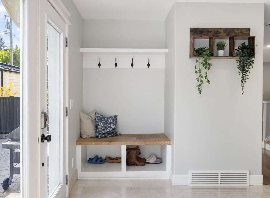 Welcome guests into a bright and organized entryway featuring a charming built-in bench with ample storage for shoes and accessories.