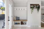 Welcome guests into a bright and organized entryway featuring a charming built-in bench with ample storage for shoes and accessories.